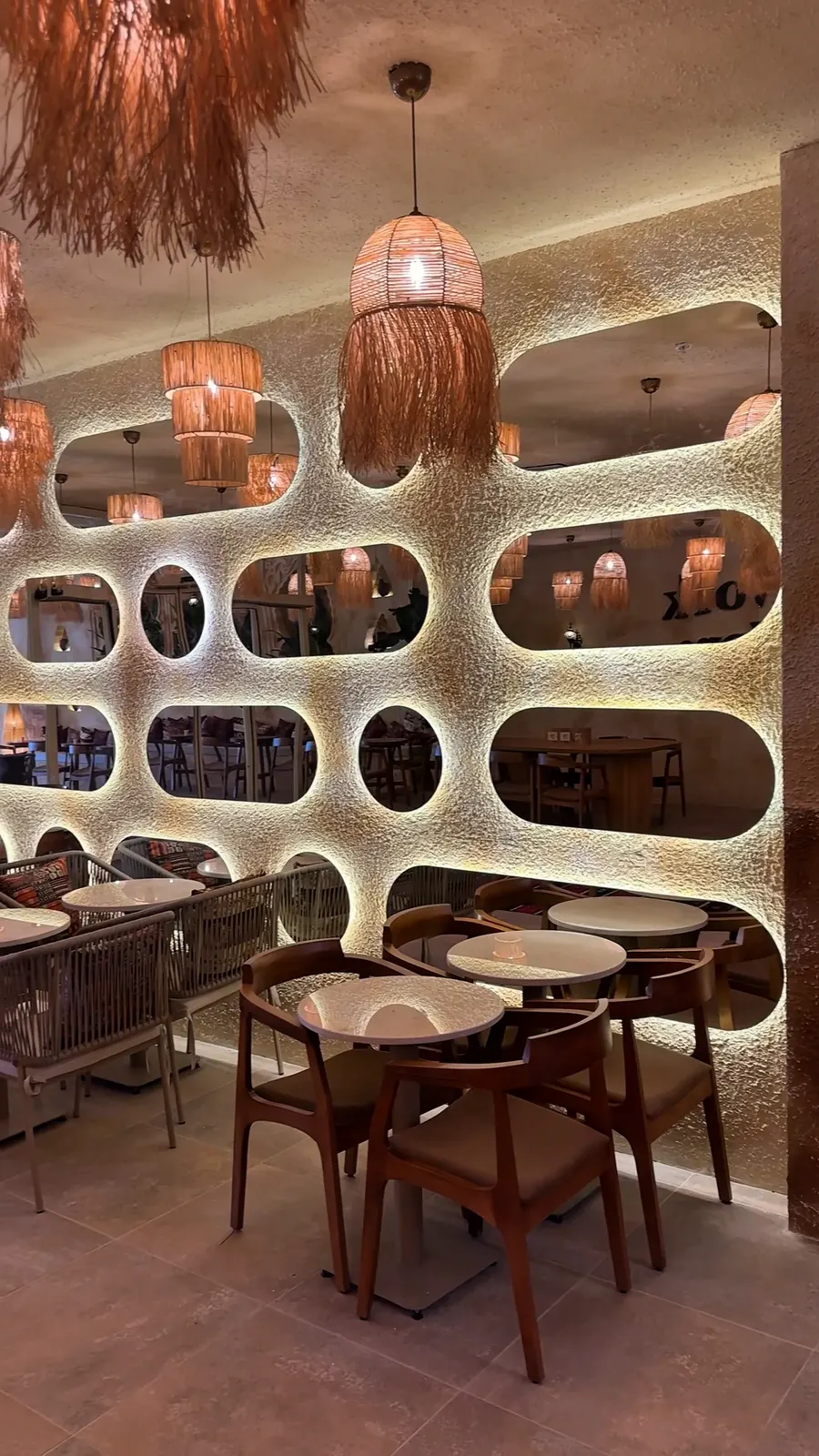 Vens Coffee'de oval nişli heykelsi duvar ve oturma alanı
