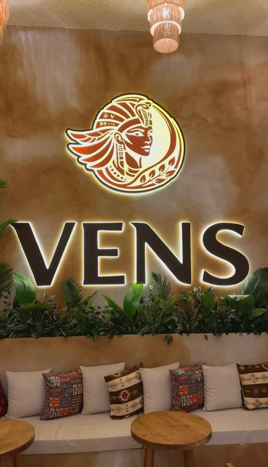 Vens Coffee'de ışıklı altın amblem ve VENS harfleri